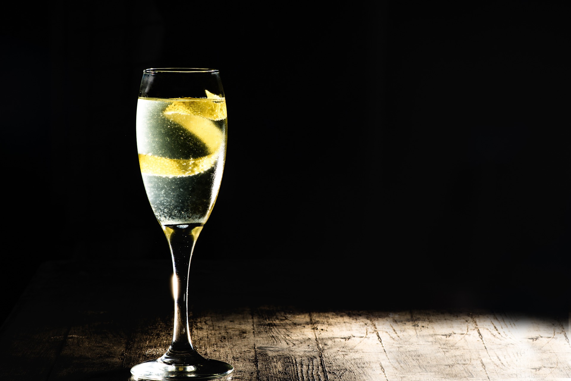 Eleganter French 75 Cocktail in einem Sektglas mit Zitronenschale