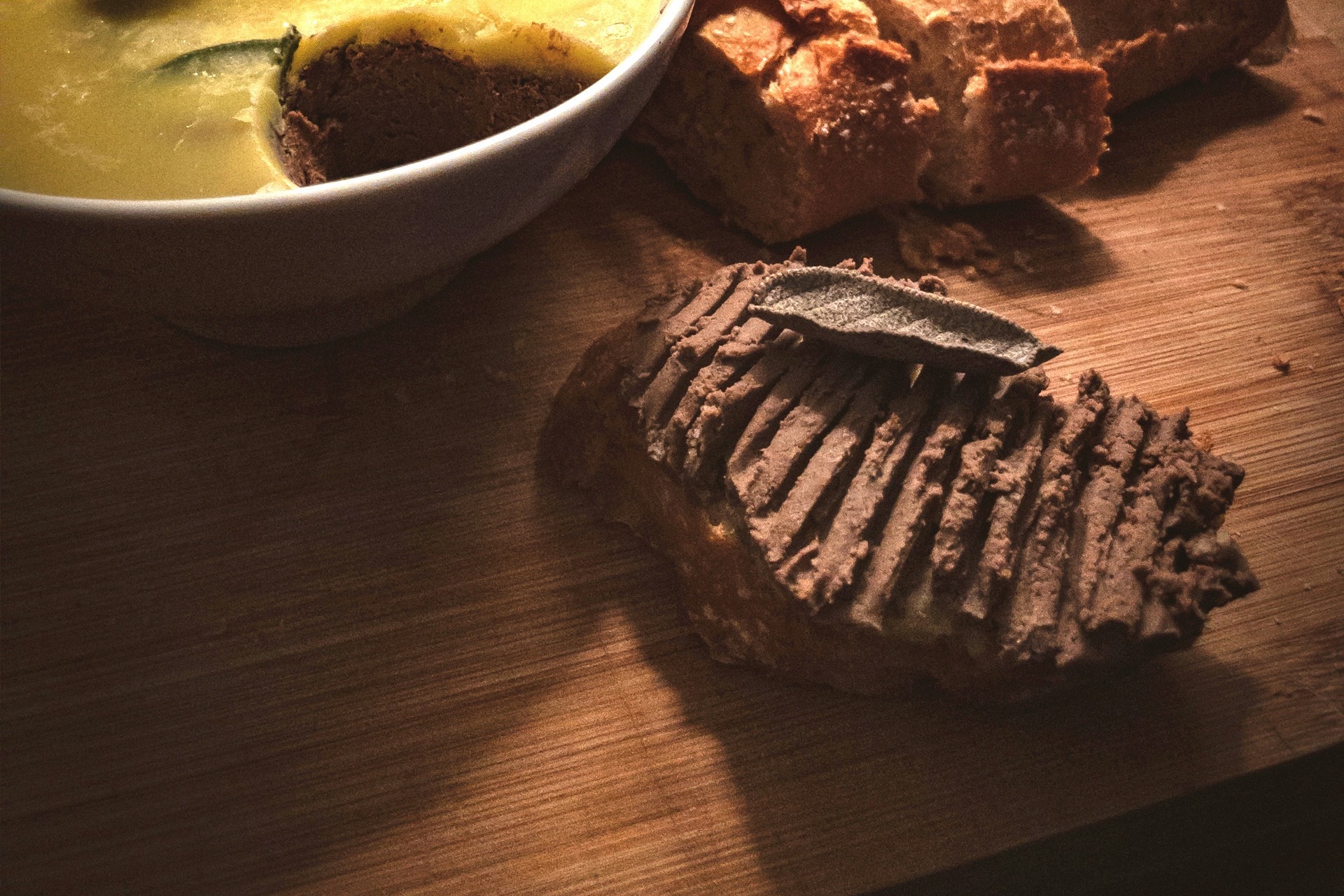 Hühnerleberparfait auf geröstetem Weißbrot auf einem Holzbrett