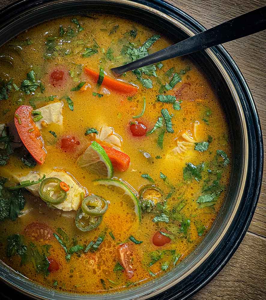 Orange Fischsuppe mit Tomaten, Limetten und grünen Kräutern