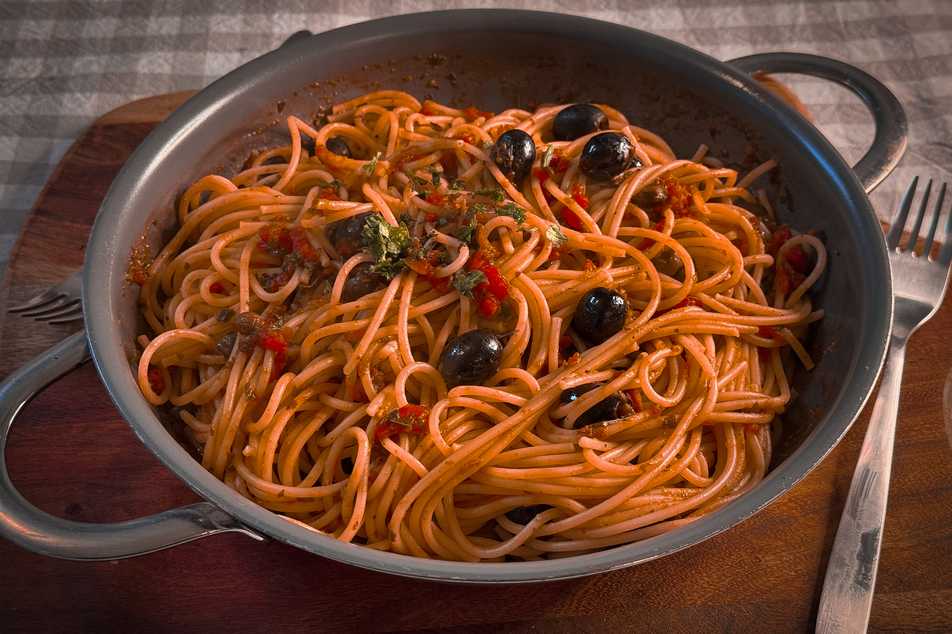 Spaghetti mit Tomatensauce, Oliven, Petersilie in einer Pfanne