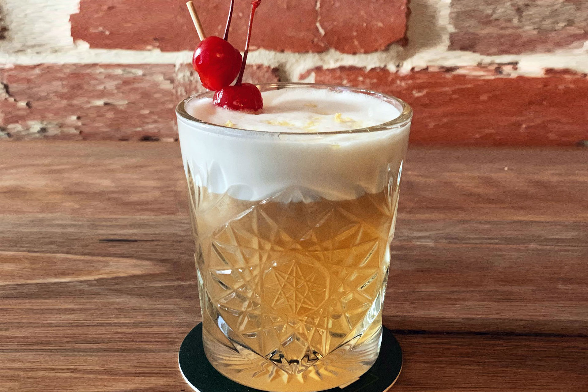Ein klassischer Whiskey Sour Cocktail mit Zitronenscheibe